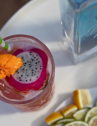 Top view close up of a tropical drink and the bottle of Yacht Life Vodka.