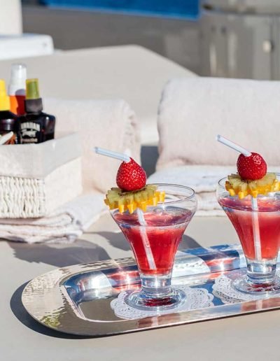 Two drinks served on a silver tray, on the top deck of a yacht
