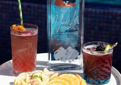 Yacht Life Vodka bottle with two drinks in front of it and a plate of fruit